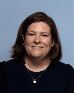 Headshot of a smiling caucasian female teacher with brown shoulder length hair.